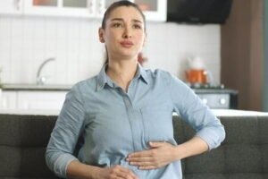 Woman-holding-stomach-with-pained-expression