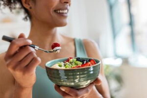 Woman-holding-a-bowl-of-fresh-fruit-and-yogurt